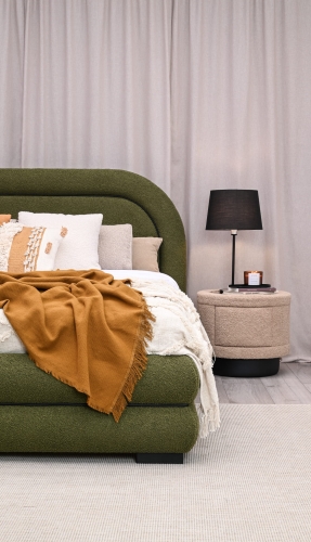 Eleganckie łóżko tapicerowane w nowoczesnej sypialni, zaokrąglony zagłówek z czarną lamówką