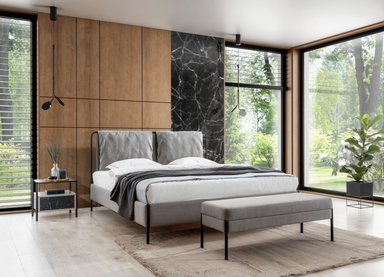 Łóżko tapicerowane na metalowej konstrukcji z miękkim, pikowanym wezgłowiem i czarnymi nóżkami. Nowoczesny design, komfort i lekkość w Twojej sypialni.