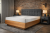 drewniane łóżko z tapicerowanym zagłówkiem
